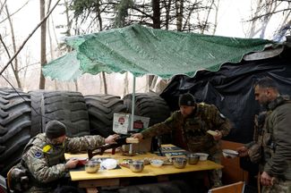 Бойцы полка полиции особого назначения «Днепр-1» за рождественской трапезой — борщ с хлебом — на передовой в Бахмуте