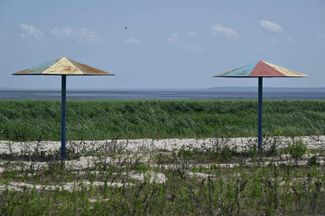 Beach umbrellas on the beach of Kakhovka Reservoir in the village of Novvorontsovka, Kherson Region in early June 2024 