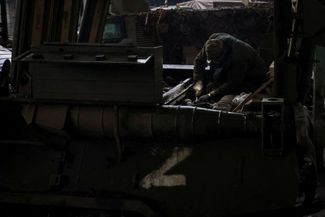 Украинский военнослужащий ремонтирует бронетранспортер, захваченный у российских войск