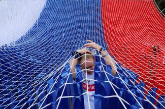 Волонтер собирает инсталляцию в цветах государственного флага в Санкт-Петербурге в День России 12 июня