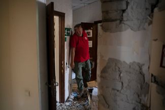 Начальник отряда быстрого реагирования Тарас Логинов ходит по поврежденному зданию украинского общества Красного Креста после российской атаки на Славянск