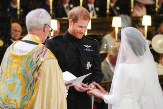 Принц Гарри надевает кольцо на руку невесты
