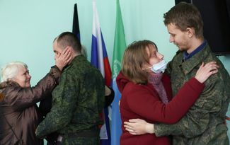 Военнослужащие, освобожденные из плена, со своими родственницами в здании администрации Новоазовска