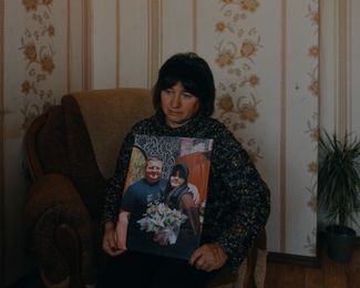 Lyubov Kozyr with a photo of her son-in-law, Anatoliy, who was killed in the missile strike, and her granddaughter, Darya. Anatoliy’s parents, Iryna and Valery Panteleiev, were also killed in the strike.