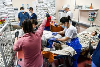 Medical staff at a children’s hospital in Zaporizhzhia treat patients seriously injured during shelling. The hospital’s windows are blocked with sandbags. 