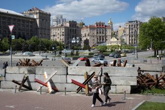 Женщины на фоне противотанковых ежей в центре Киева. 27 апреля 2024 года