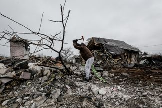 Житель Киева расчищает завалы после падения обломков российской ракеты