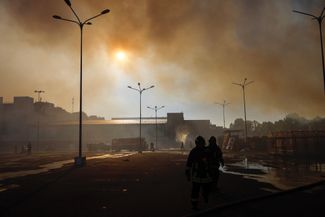 Пожарные работают у торгового центра, который обстреляли российские войска