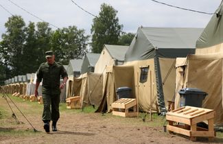 A Belarusian soldier walks across a Wagner camp in Osipovichi, Belarus
