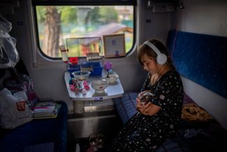 Девятилетняя Оля играет со своей домашней крысой Пикой в переоборудованном вагоне поезда, который служит временным убежищем для ее семьи и других людей, потерявших свои дома во время войны. Ирпень