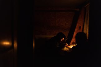 Жители Херсона ужинают при свечах, ноябрь 2022 года. В ноябре в городе не было воды и электричества: после отступления из города российские войска продолжили обстреливать объекты инфраструктуры Херсона