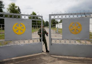 Белорусский военнослужащий закрывает ворота лагеря под Осиповичами
