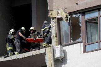 Спасатели эвакуируют человека из разрушенного дома в Шевченковском районе Киева. В результате авиаудара один человек погиб, шестеро пострадали. Среди пострадавших гражданка России и ее семилетняя дочь
