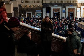 People wait to board an evacuation train at Kyiv’s central train station