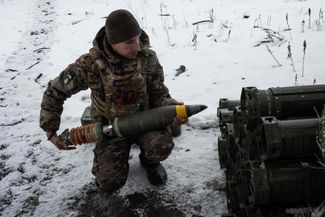 Украинский военный заряжает миномет
