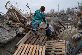 Жительница Бахмута Людмила переходит ручей по разрушенному мосту