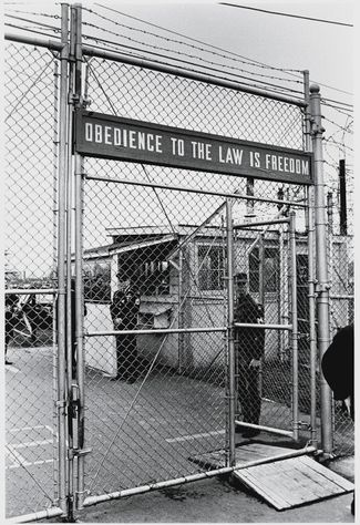 Сотни человек, не желавшие идти на войну во Вьетнаме, побывали в тюрьме на военной базе Форт-Дикс в штате Нью-Джерси. Противники войны на протяжении всего призыва устраивали акции возле базы Форт-Дикс. На фото, сделанном 12 октября 1969 года, показана табличка над входом на территорию тюрьмы. На ней написано: «Повиновение закону — это свобода»