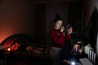Жители Киева в своей квартире во время отключения электричества. 30 ноября 2022 года