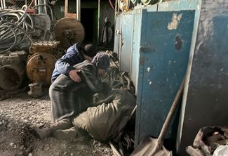 Жители Донецка у тела горняка, погибшего в шахте имени А. А. Скочинского в Кировском районе. Во время обстрела в шахте пострадали девять горняков, одного из них не удалось спасти