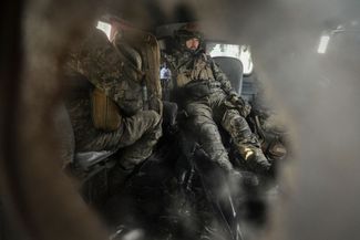Бойцы ВСУ в полевой машине скорой помощи рядом с погибшим товарищем