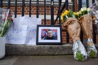 A portrait of Navalny and some flowers outside of the Russian Embassy in London.