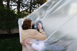 Мишель Грант (справа) впервые за несколько месяцев после начала пандемии обнимает свою мать, Мэри Грейс Силео, через пластиковую занавеску на веревке для сушки белья. Нью-Йорк, 24 мая 2020 года
