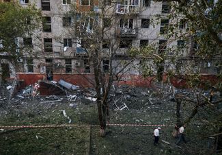 Жители Краматорска идут мимо дома, пострадавшего от российского ракетного удара 31 августа. По <a href="https://hromadske.ua/posts/raketi-z-byelgoroda-po-harkovu-ta-obstril-nikopolya-situaciya-u-regionah-zranku-31-serpnya" rel="noopener noreferrer" target="_blank">данным</a> украинской стороны, в городе, который находится под контролем ВСУ, были обстреляны по меньшей мере четыре жилых многоэтажки. О пострадавших не сообщается