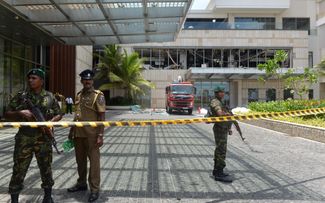 Сотрудники правоохранительных органов у входа в отель Shangri-La в Коломбо.