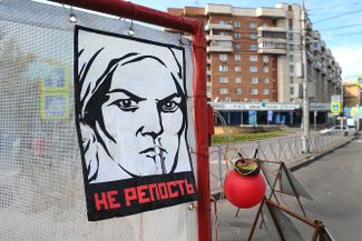 A modified Soviet-era propaganda poster that reads “NO REPOST” hangs in Novosibirsk during a public art action against the prosecution of social media activity. 2018