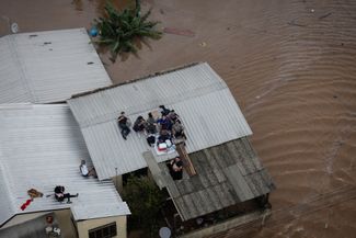 Жители Каноаса ожидают на крыше частного дома эвакуации по воздуху (на вертолете) во время проведения ВС Бразилии спасательной операции, 4 мая