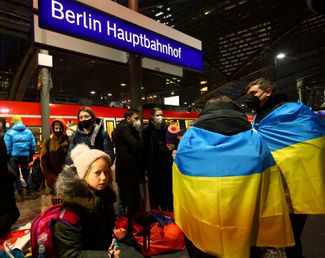 Волонтеры с украинскими флагами встречают семью из города Винница. Берлинский Центральный вокзал. 28 февраля 2022 года