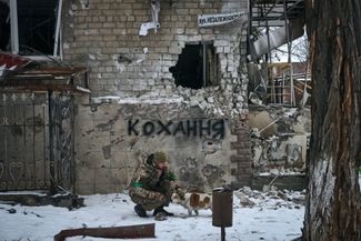Украинский военный с собакой. Надпись на стене переводится как «Любовь»