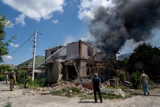 Сотрудники Государственной службы Украины по чрезвычайным ситуациям тушат пожар в жилом квартале Херсона, разрушенном в результате российского обстрела