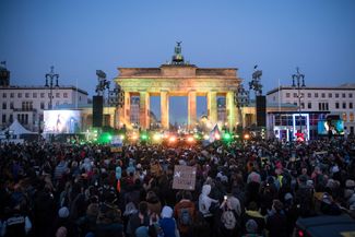 Участники акции солидарности с Украиной на концерте перед Бранденбургскими воротами в Берлине. 20 марта 2022 года