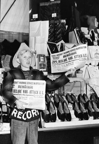 Мальчик продает газеты в Калифорнии с новостью об атаке на Перл-Харбор на первой полосе