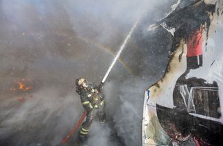 Пожарные работают на месте попадания одной из ракет