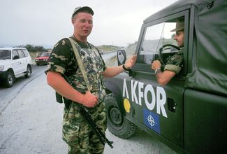 Российский солдат и автомобиль KFOR на блокпосте в Приштине, июль 2000 года