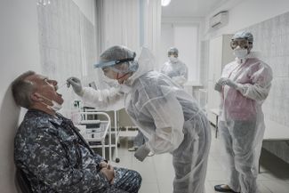 A nurse takes swabs for a coronavirus test