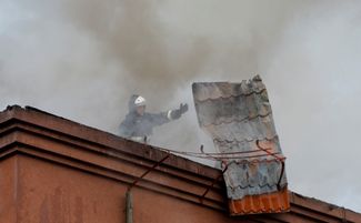 Пожарный тушит огонь на крыше здания прокуратуры в аннексированном Донецке