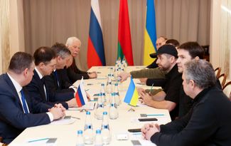 The Russian (left) and Ukrainian (right) delegations during negotiations in Gomel, Belarus