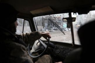 Военнослужащие ВСУ проезжают по разрушенной улице в Бахмуте