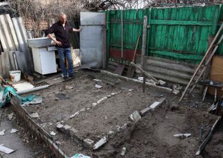 Максим, житель города Рубежное Луганской области, показывает могилу своего соседа, погибшего под минометным обстрелом. Похоронить его Максиму пришлось прямо у себя в огороде.