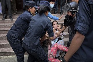 Police remove Roji Pun from the Nepali Foreign Ministry building