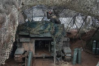 Украинский военнослужащий маскирует 155-миллиметровую самоходную артиллерийскую установку М109 «Паладин»