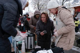 Волонтеры раздают пожилым украинцам еду и зимние перчатки в Киеве. Дневная температура в украинской столице в первые дни декабря — от +5 до −4 градусов. 19 ноября 2022 года