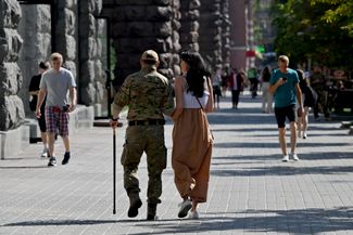 Раненый украинский солдат вместе с девушкой на одной из центральных улиц Киева