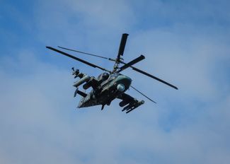 A Russian attack helicopter flies over Panteleimonivka, a village less than 20 kilometers (12 miles) from Avdiivka.