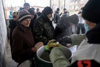 Жители Купянска в очереди за горячей едой, которую им раздают волонтеры организацииWorld Central Kitchen