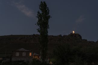 A cross in Chambarak, an Armenian border town. Many such crosses have appeared in recent decades, especially in rural areas. They are visible from the road and only glow at night. Some Chambarak residents say they deliberately drive past this cross before heading home.