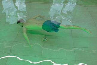 Боец ВСУ Алексей, которому ампутировали ногу, плавает в бассейне реабилитационного центра во Львове